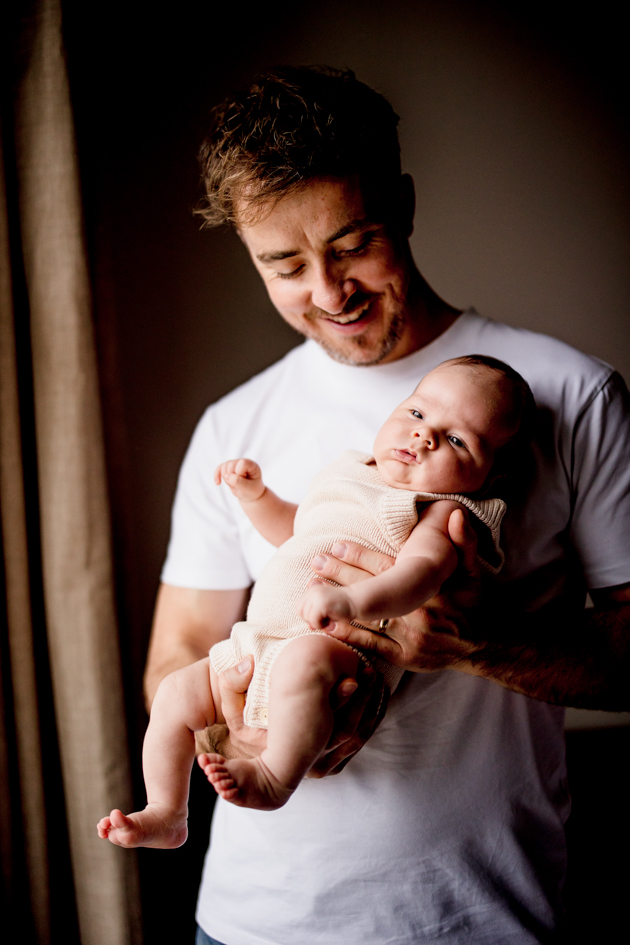 In-home natural newborn photo shoot at clients home featuring baby and Dad in natural light 