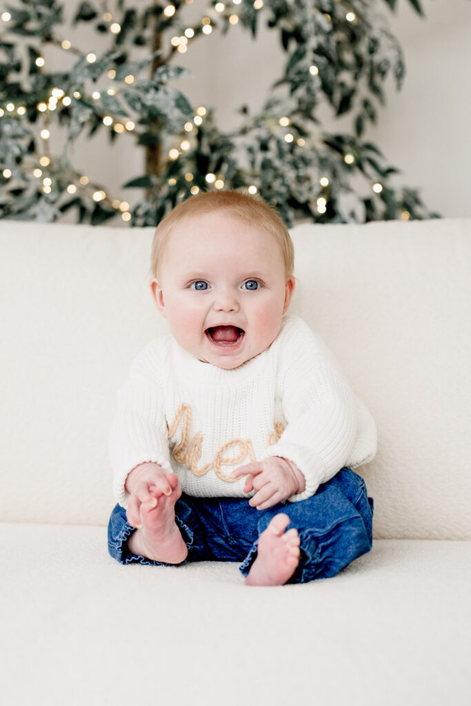 Little girl playing with toes at six month milestone session 